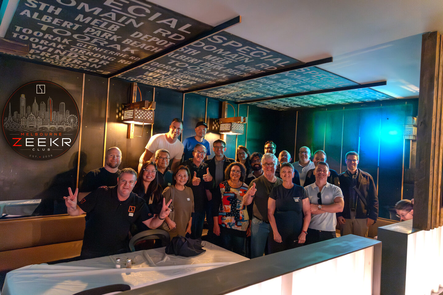 A group of Melbourne ZEEKR owners and guests smiling together at the steak dinner.